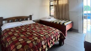 A bedroom with a wooden ceiling, two beds, a window with curtains, and a view of the outside. - Gaudys Hotel (San José)