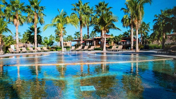 A large outdoor swimming pool surrounded by palm trees and lounge chairs. - Luxury Suite, The Islands of Loreto - stunning natural beauty in Mexico (Loreto)