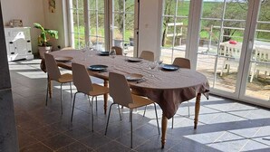 En matplats med ett stort bord, stolar och utsikt genom stora fönster.