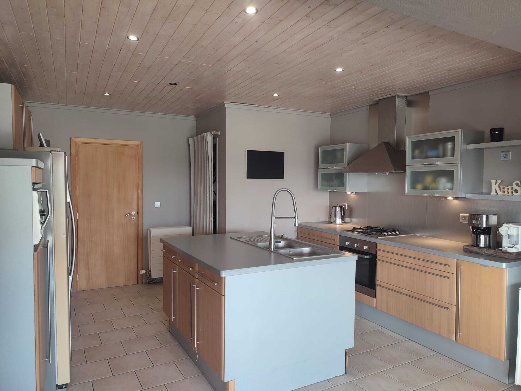 Een oven, een kookplaat, een kinderstoel, eettafels