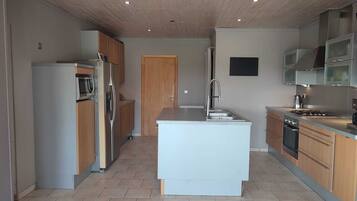 Een oven, een kookplaat, een kinderstoel, een eettafel