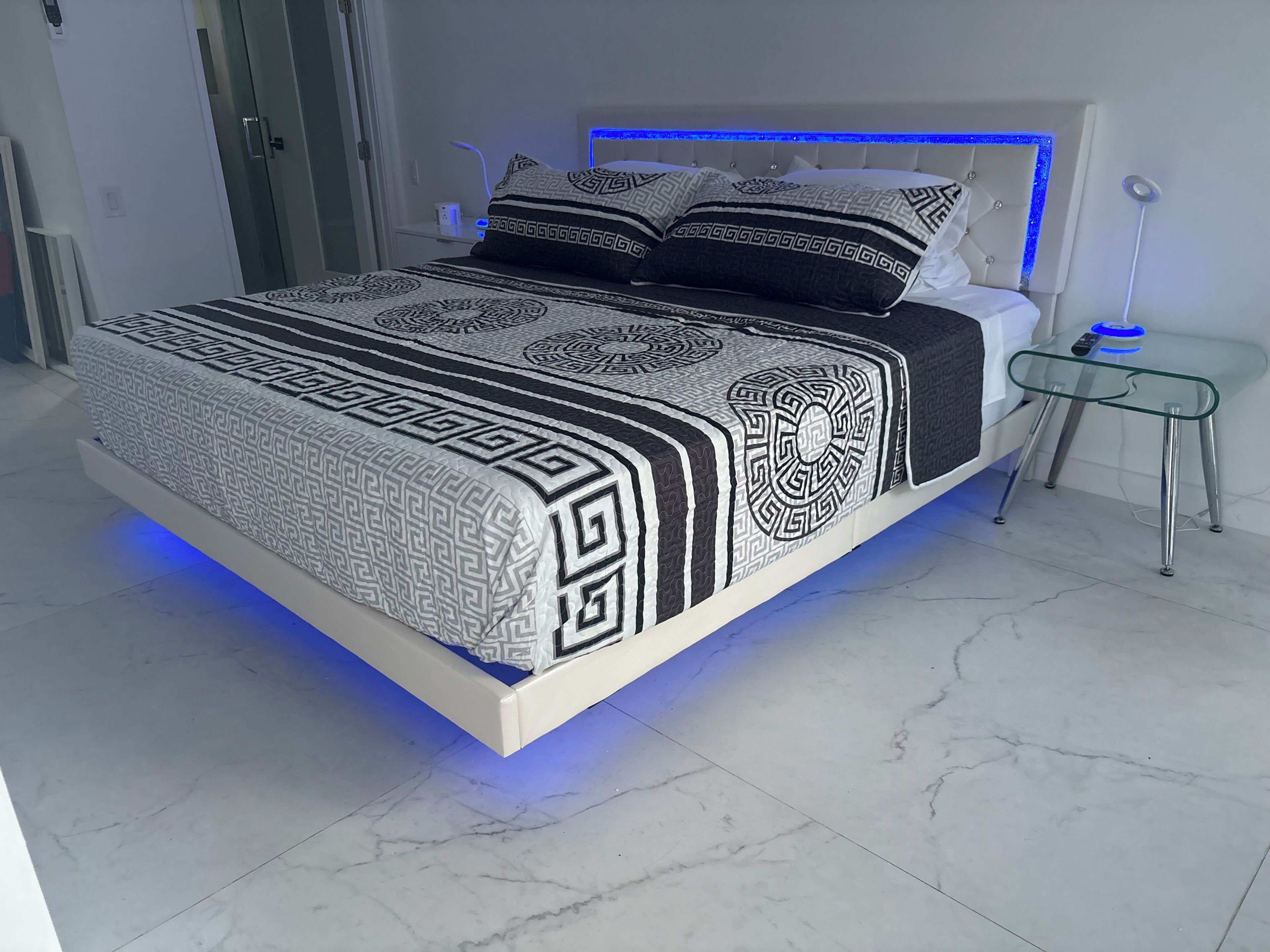 Ein modernes Schlafzimmer mit Bett, Nachttischen und einem Beistelltisch.