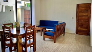 Una stanza con un tavolo da pranzo, sedie, un divano e una ventola a soffitto.