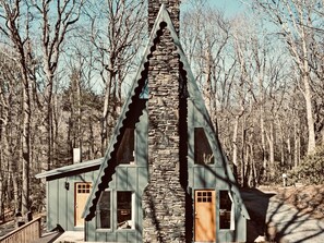 A cabin with a stone chimney, two windows, and a door. - A-Frame in the heart of Boone (Boone)