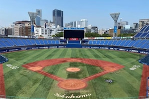 A baseball stadium with a clear view of the field, advertisements, and city skyline in the background. - EXECUTIVE HOTEL GRAND GARDEN - Adult only (Yokohama)