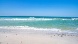 A beach with clear turquoise water and white sand.