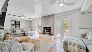 A spacious living room with a fireplace, a sectional sofa, and a large window providing natural light.