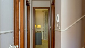A hallway with wooden doors, a radiator, and a desk with a lamp. - Villetta Desiderio Apartment (Giardini Naxos)