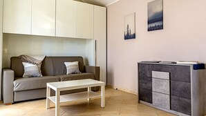 A modern living room with a sofa, a coffee table, and a cabinet. - Villetta Desiderio Apartment (Giardini Naxos)