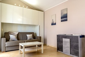 A modern living room with a sofa, a coffee table, and a cabinet. - Villetta Desiderio Apartment (Giardini Naxos)