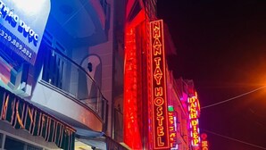 A building with neon signs for "Nhat Nhat Hostel" and "Danh Diep." - Nhan Tay Hostel (Can Tho)