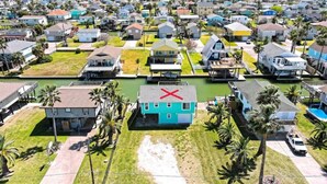 A residential area with houses, a canal, and palm trees. - Bahama Waves (Jamaica Beach)