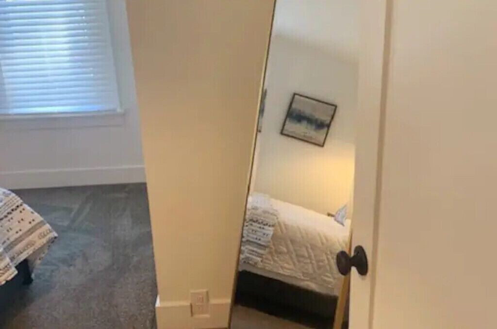 Een slaapkamer met een bed, een deur en een raam met zonwering.