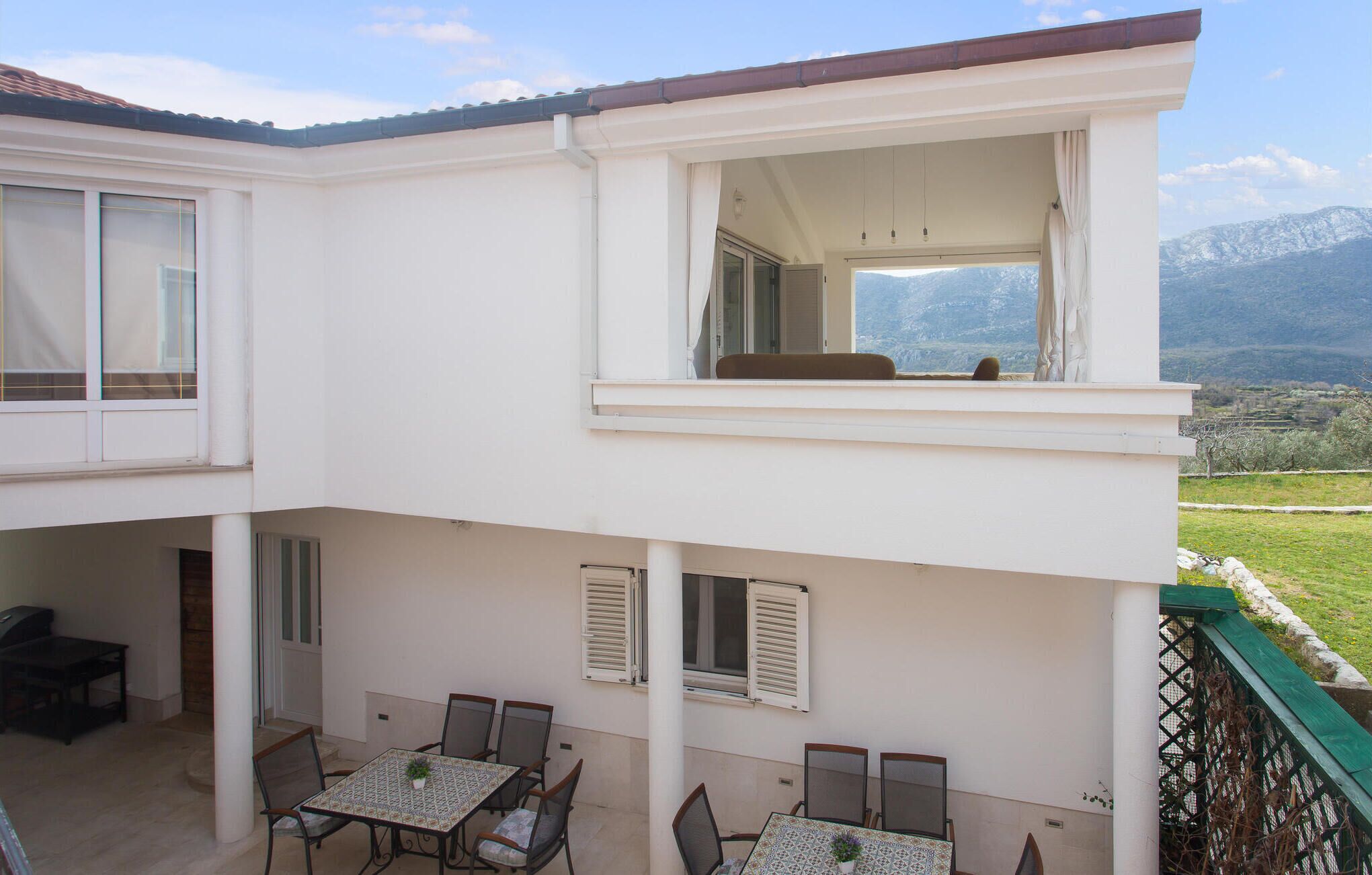 A two-story building with a balcony and a dining area.