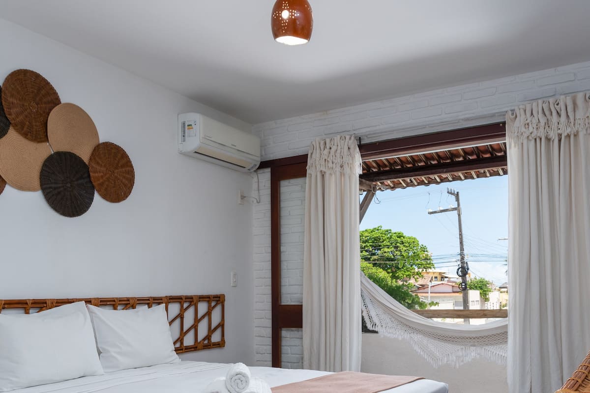 Ein Hotelzimmer mit Bett, Hängematte und Meerblick.