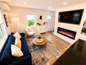 Una Smart TV, una chimenea, libros, una impresora