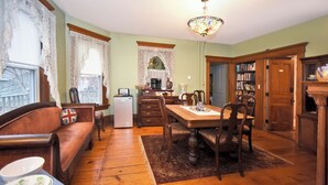 A traditional dining room with a wooden table, chairs, and a chandelier. - Blooming Inn (Shelburne Falls)