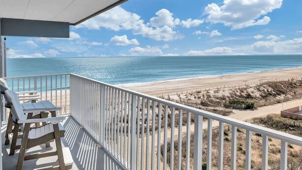A balcony with a view of a beach and ocean. - Sunrise & Sunset Oceanfront Condo (Ocean CIty)