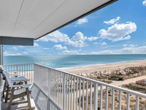 A balcony with a view of a beach and ocean. - Sunrise & Sunset Oceanfront Condo (Ocean CIty)