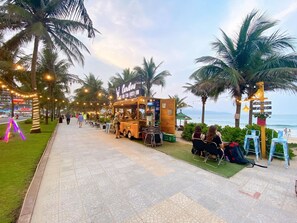A food truck named 'Caribou' on a paved walkway with palm trees and chairs for seating. - Muong Thanh Apartment Luxury 03 bedroom (Da Nang)
