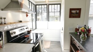 A kitchen with a stove, oven, and a large window. - 1912 Historic Ballard Craftsman
5 Bed • 2 Bath • Yard • Parking (Seattle)
