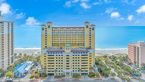 A multi-story hotel with a central tower, located near a beach with clear blue skies. - Amazing OCEAN FRONT Views!  Newly Renovated!   Walking Distance to All  Myrtle.  (Myrtle Beach)