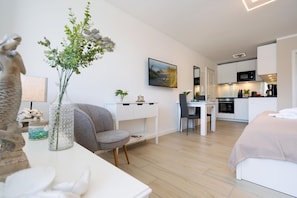A modern, well-lit room with a dining area, kitchenette, and a bed. - Strandwärts - Modern app. with balcony, sea view, parking space, WLAN. (List)