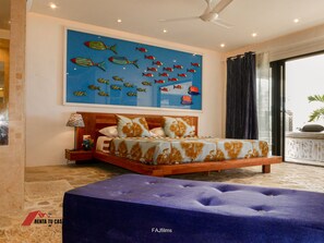 A bedroom with a bed, a nightstand, a ceiling fan, a large fish mural, and a view of the outside.
