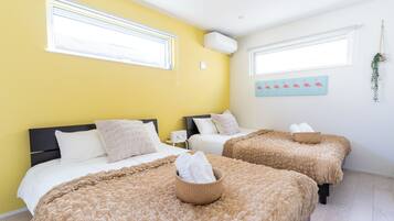 A hotel room with two beds, a yellow wall, and a painting of flamingos.