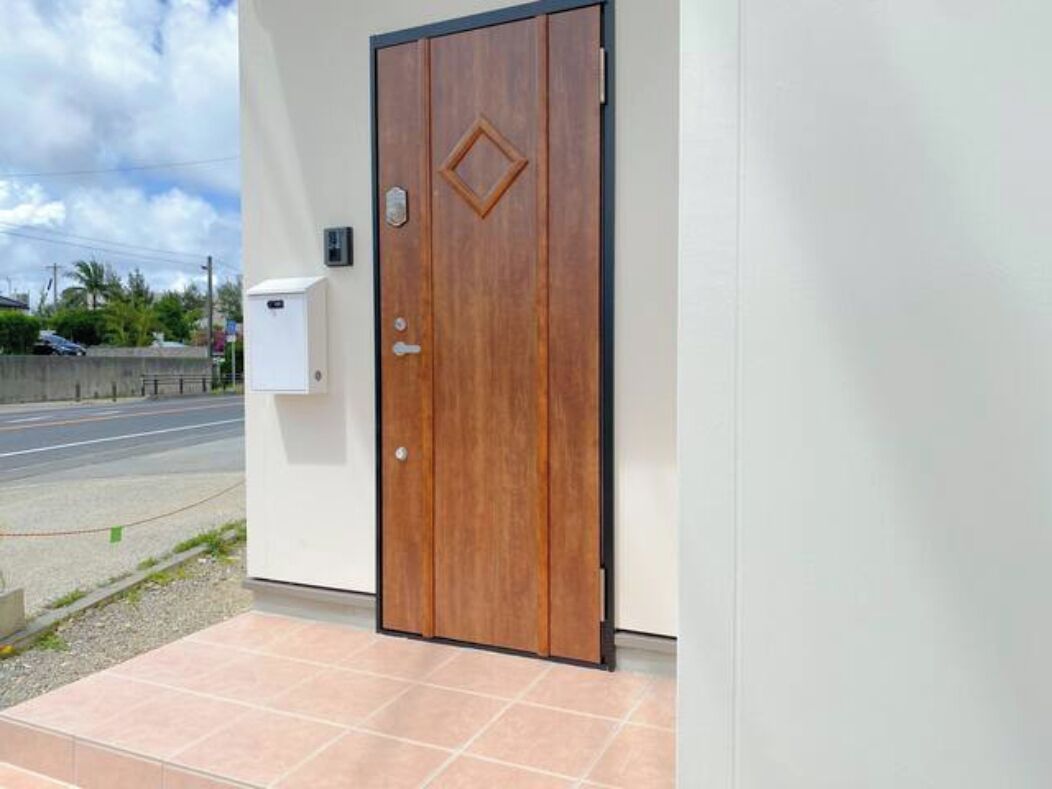 Une porte en bois avec une petite fenêtre et une boîte aux lettres fixée au mur.
