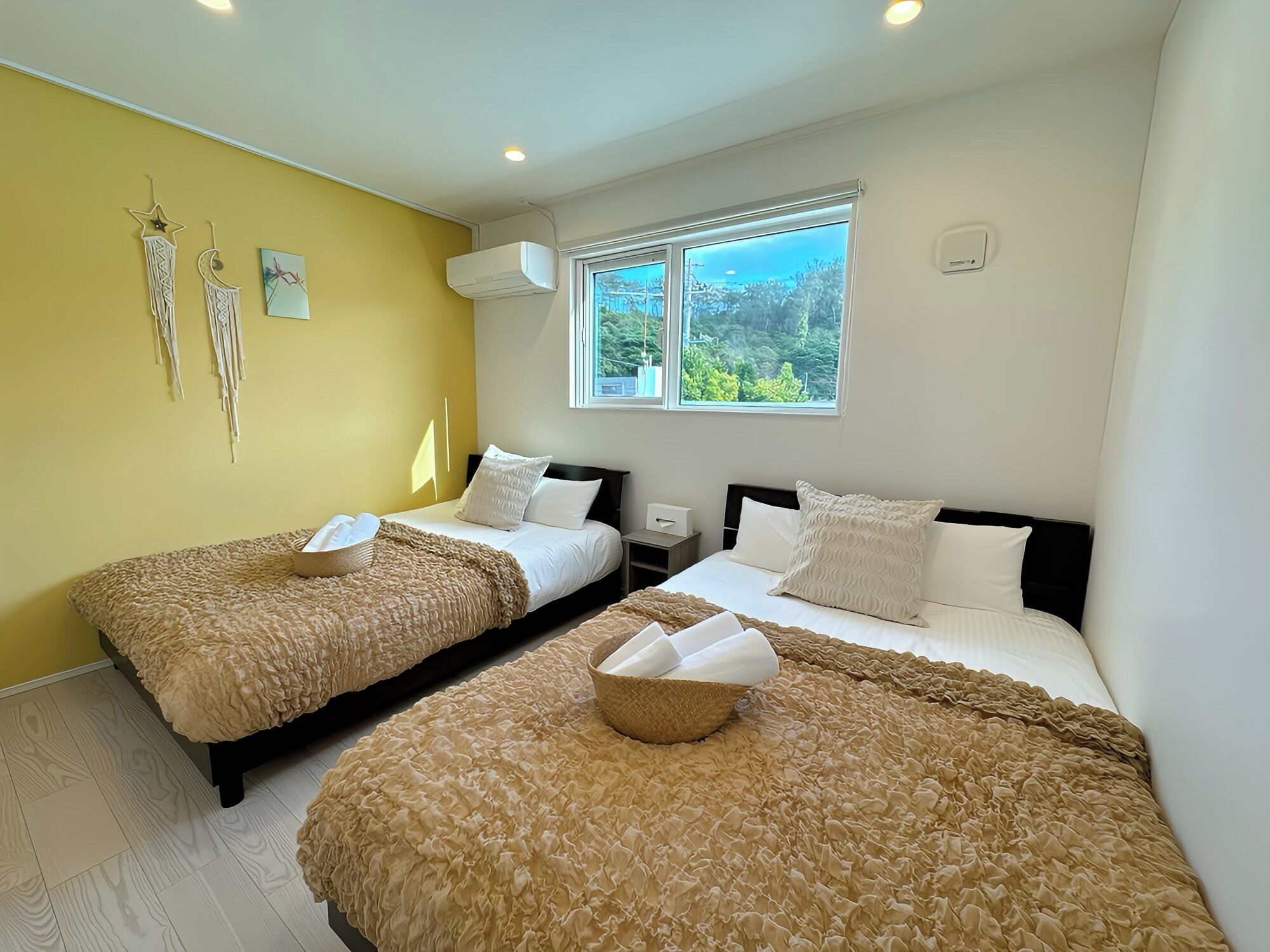 Een hotelkamer met twee bedden, een raam met uitzicht en een airconditioning.