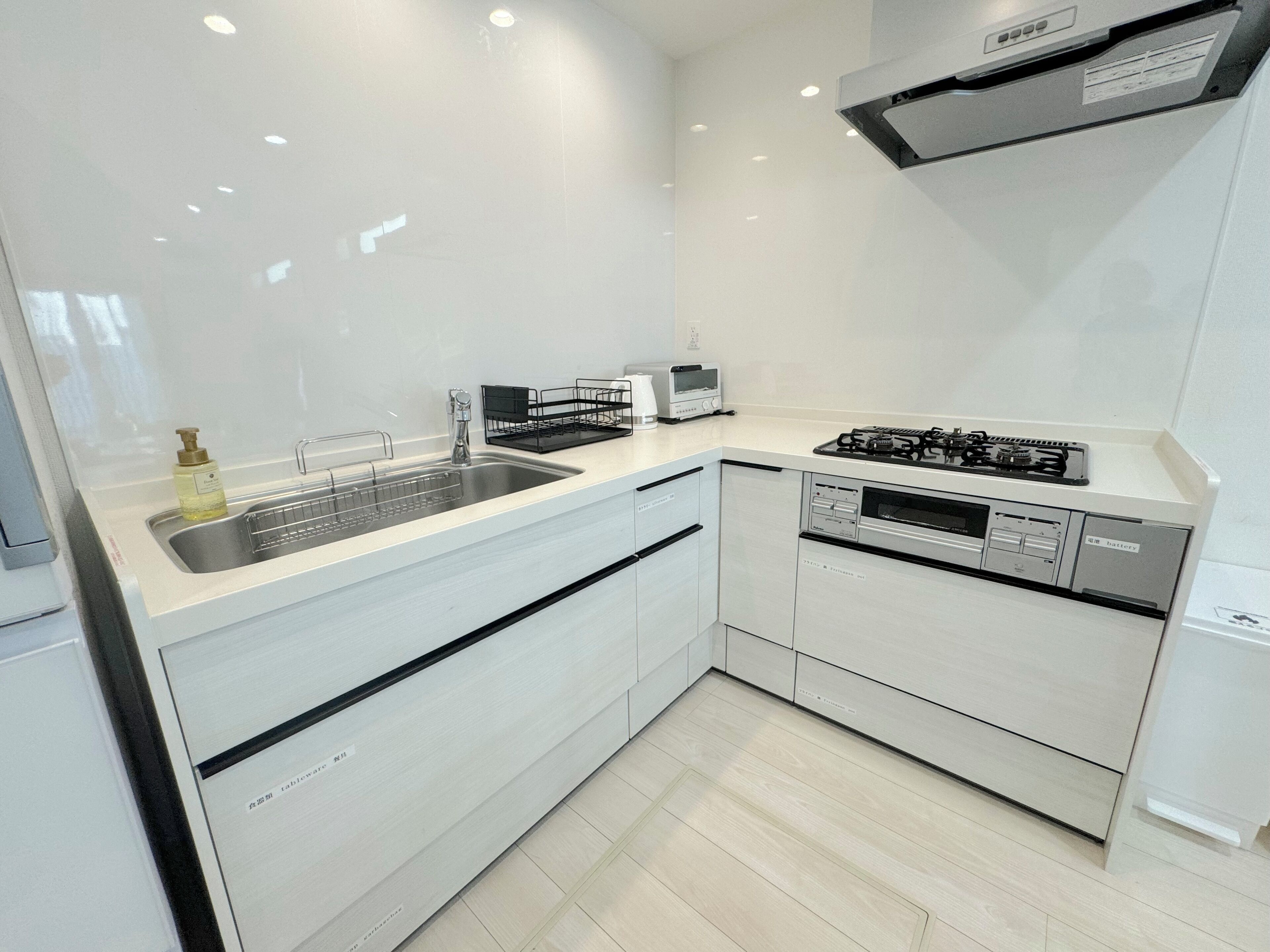 A modern kitchen with a stainless steel sink, a built-in oven, and a gas stove.