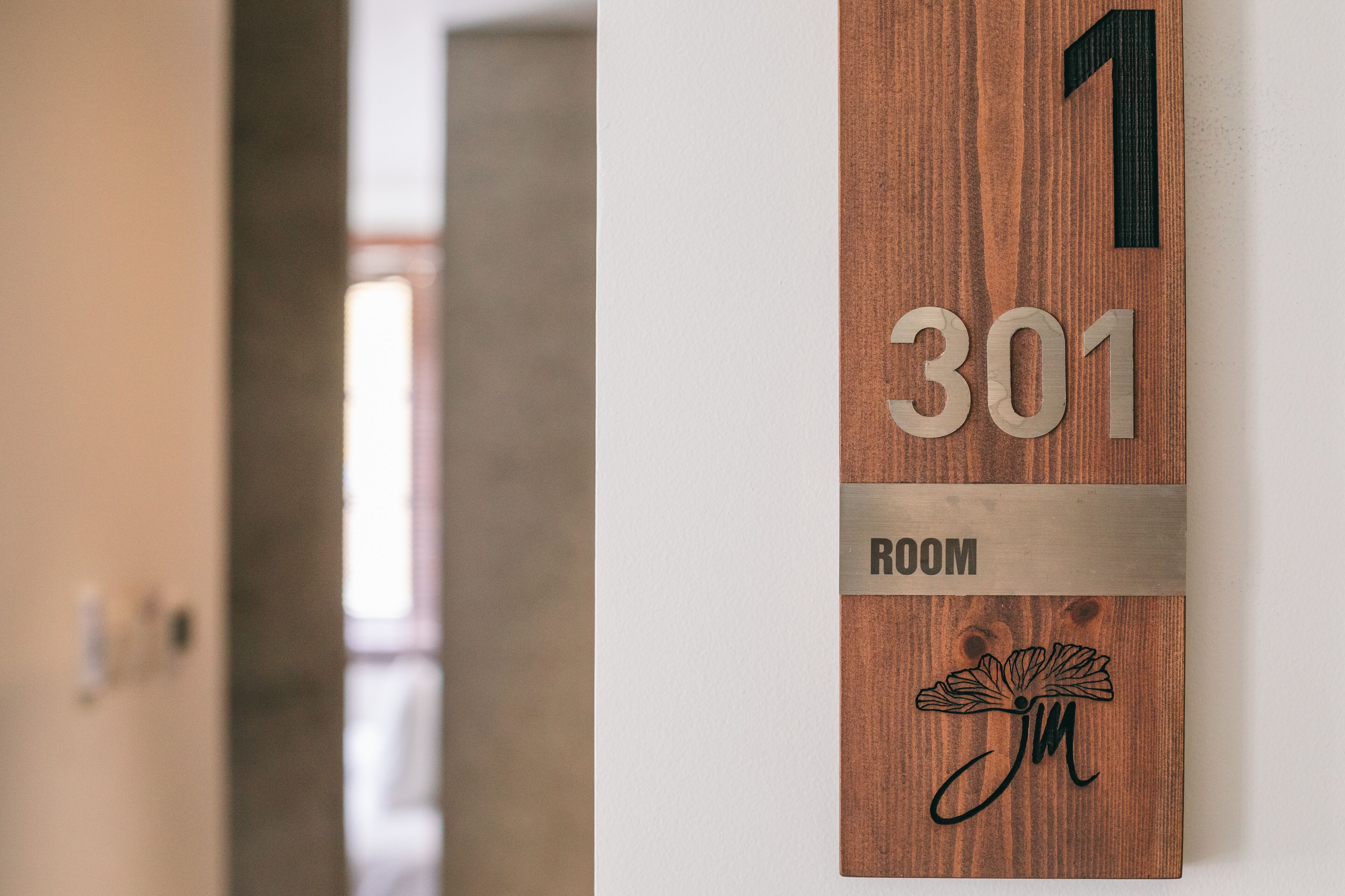 A wooden room number sign with the number 301 and the word "ROOM" below it.