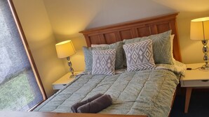 A neatly made bed with patterned pillows, a wooden headboard, and two bedside lamps. - *WI-FI & Netflix* Super Comfy Accom, 21meter Long  Boat Parking Available!! (Portland)