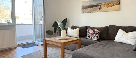 Una sala moderna con un sofá, una mesa de centro y un cuadro en la pared.