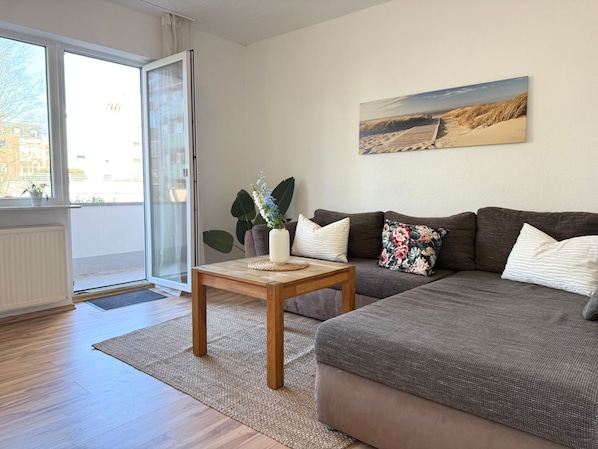 Una sala moderna con un sofá, una mesa de centro y un cuadro en la pared.