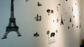 A wall with various stickers depicting landmarks and objects, including the Eiffel Tower, hot air balloons, and other travel-related items.