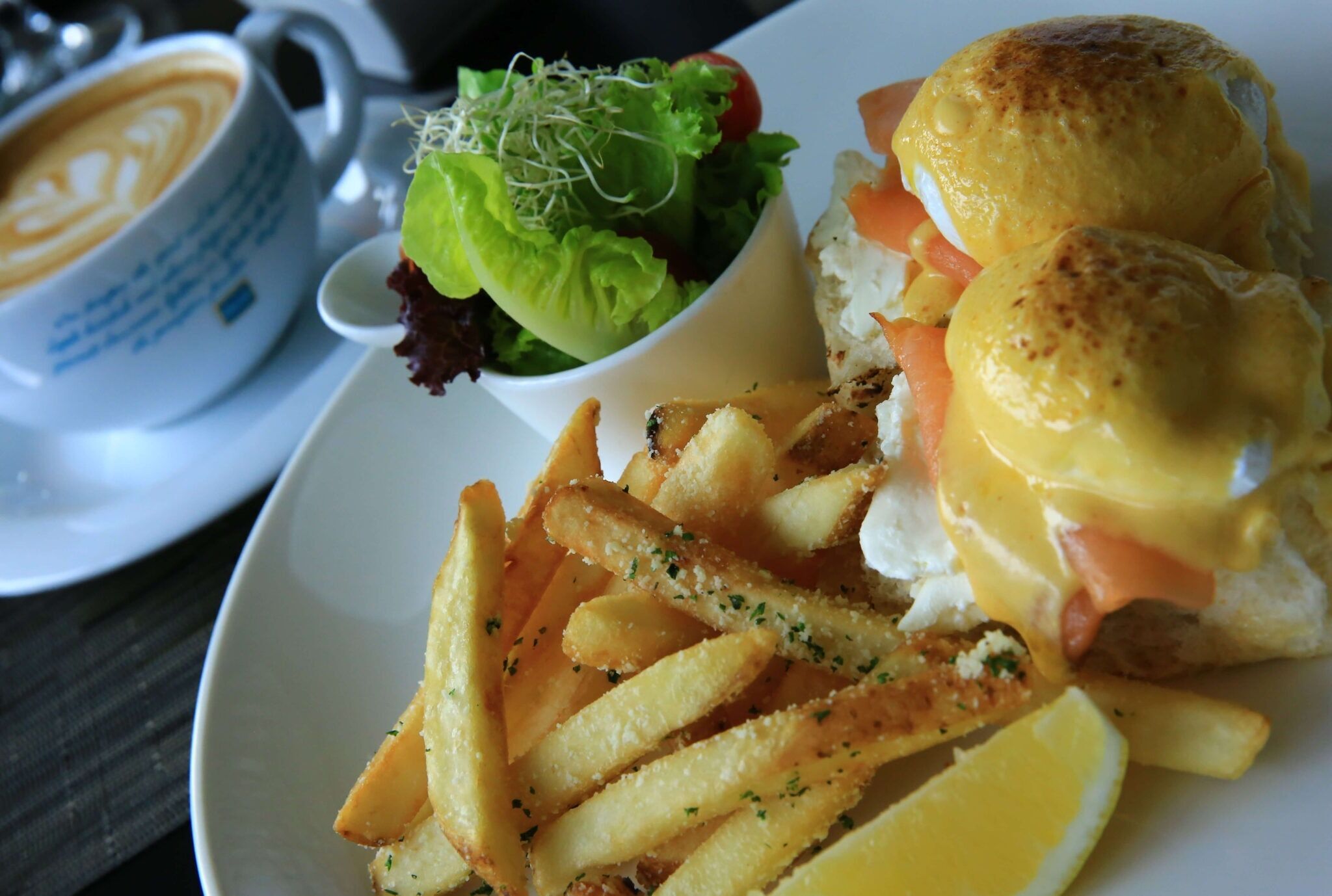 Un plato con un sándwich, papas fritas y una ensalada.