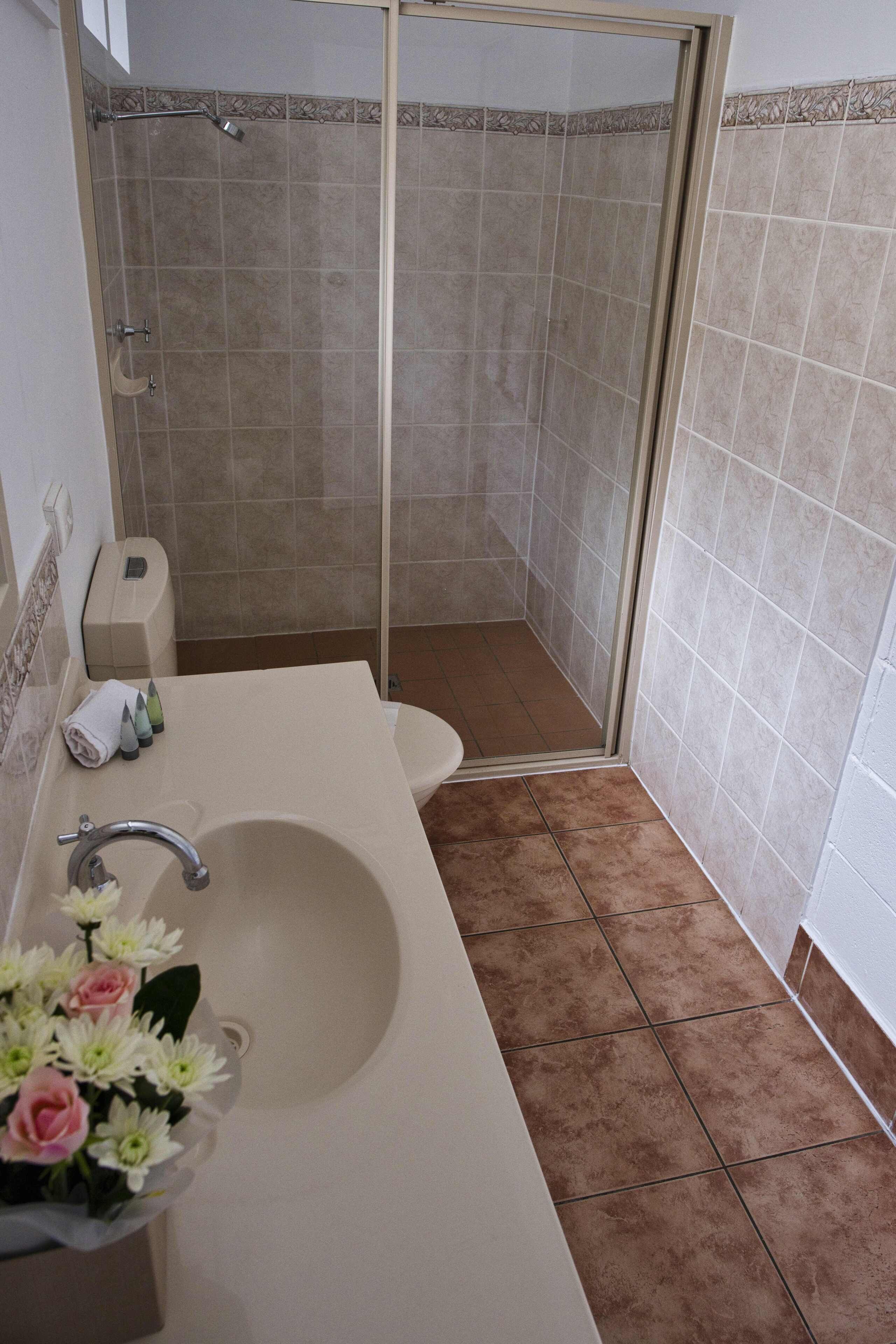 Un baño con ducha, inodoro y lavamanos.