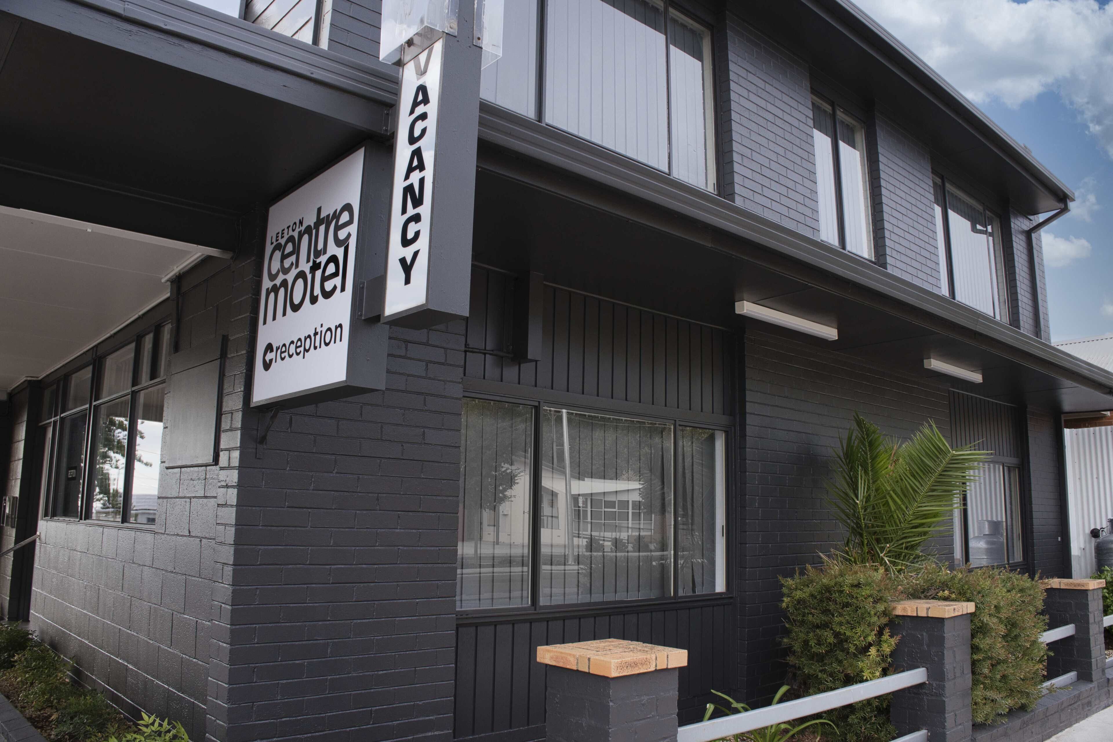 A two-story building with a sign indicating it is a vacancy.