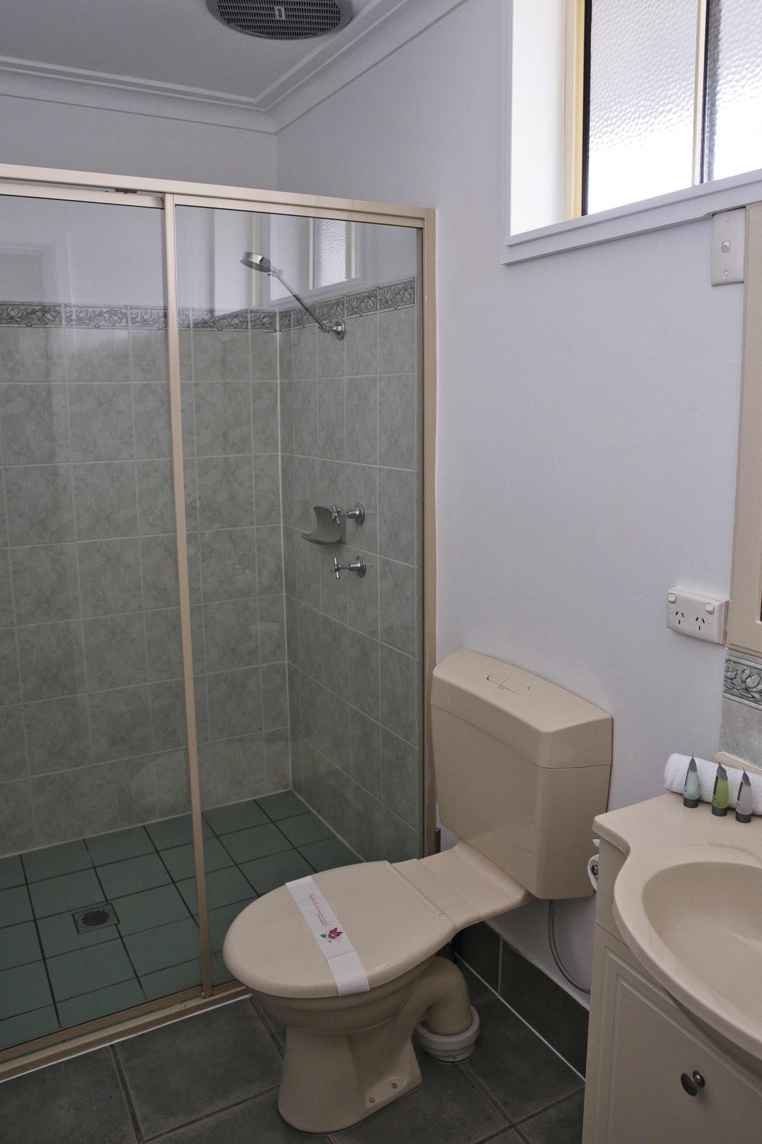 Ein Badezimmer mit Duschkabine, Toilette und Waschbecken.
