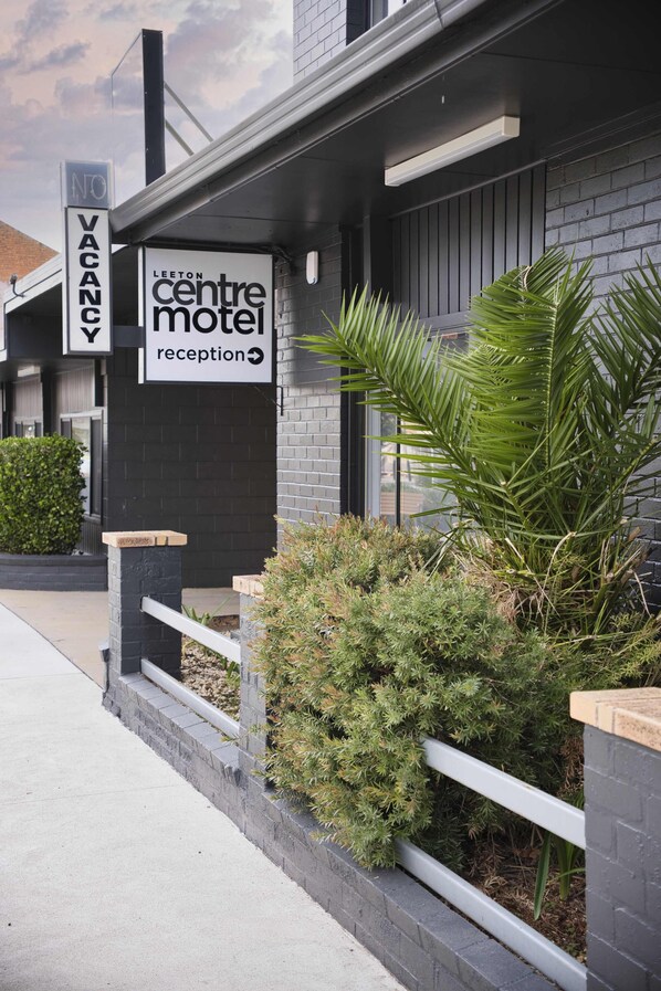 A building with a reception area for a motel, a 'NO VACANCY' sign, and a sign indicating the motel's name. - Leeton Centre Motel (Leeton)