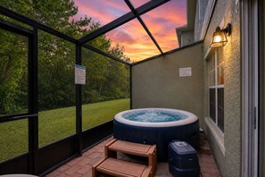A hot tub in a covered outdoor area with a view of a sunset. - 4BR/3BA TownHome with private hot tub, Near Disney (Kissimmee)
