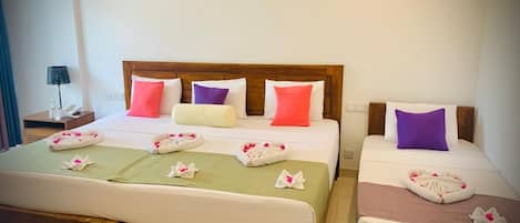 A double bed with a wooden headboard, two bedside tables, and a green bedspread.