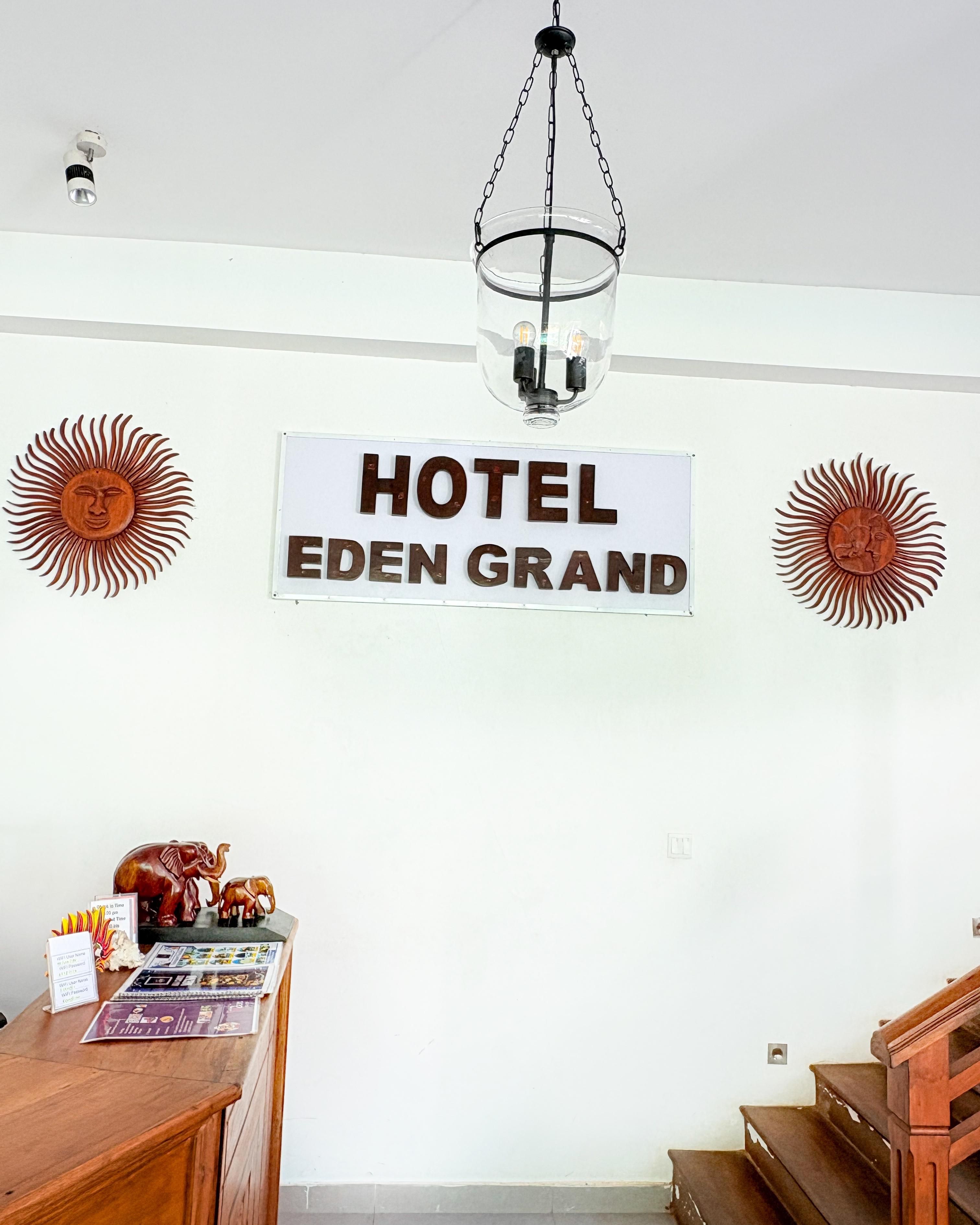 A hotel sign, a wooden desk with a computer, and a staircase.