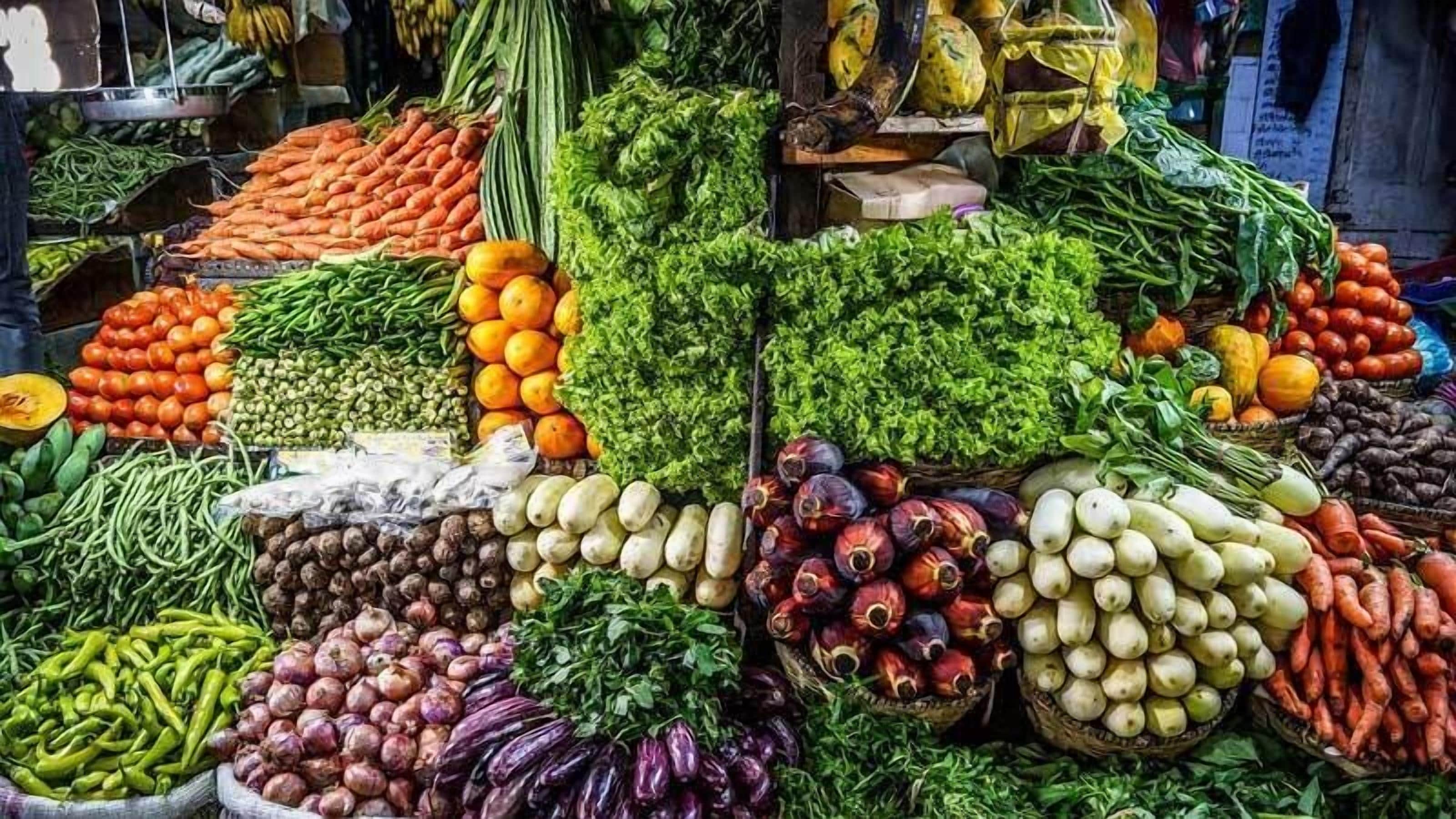 Une variété de légumes et de fruits frais exposés sur un étal de marché.