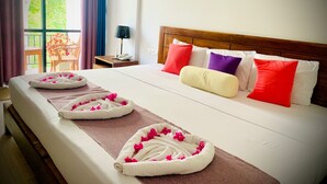 A hotel room with a large bed, a wooden headboard, and a view of greenery through the window. - Eden Grand (Dambulla)