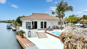 Una casa con piscina, un muelle y vista al agua.