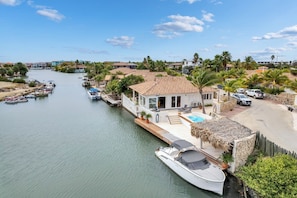 A coastal property with a dock, a swimming pool, and a house with a tiled roof. - Kas Jacco, waterfront villa with pool (Kralendijk)