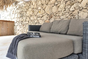 A sofa with a book titled 'DE MACHINE' placed on it.